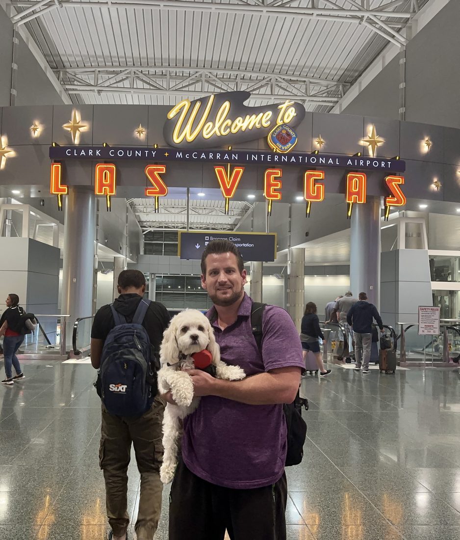 Adam holding Maya under the Welcome to Las Vegas sign at the airport